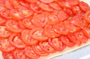 Garnir la pâte de tranches de tomates