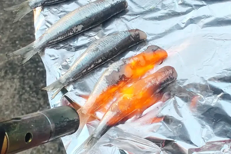 Cuisson des sardines à la flamme