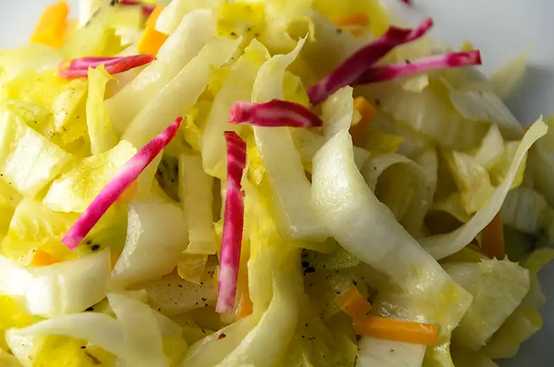 Des bâtonnets de betterave chioggia dans la salade d'endives